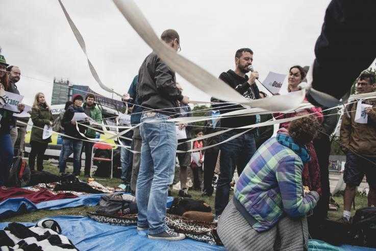 Eine Gruppe von Menschen, die in verschiedenen Positionen aufstehen und einen Faden halten, der sie alle verbindet