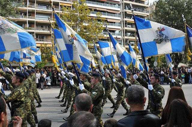 Greek soldiers marching with blue and white flags