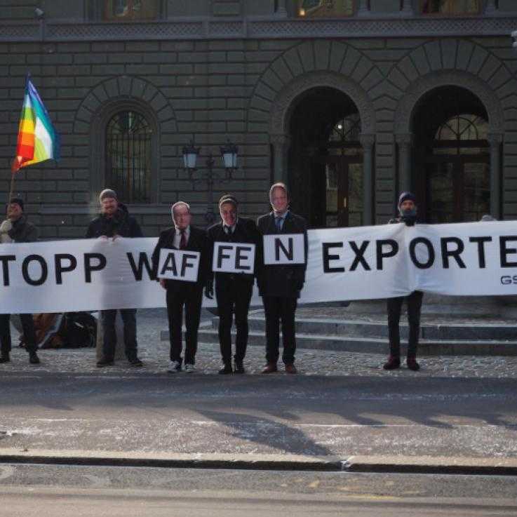 Swiss activists hold a banner reading "Stop the arms trade"